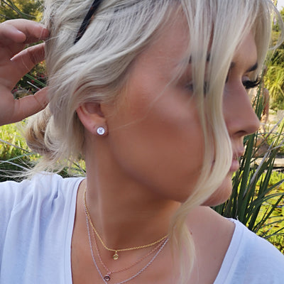 Blonde Modelwearing silver button earrings and three layered Button necklaces