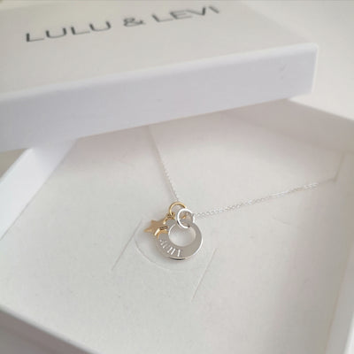 Silver sun moon star pendant engraved with a name and featuring a little gold star charm inside a white lulu & levi gift box